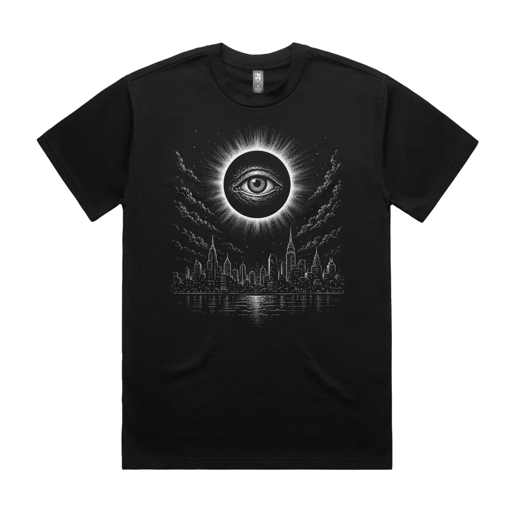 Front mockup of Vestigium XIII luxury 280 GSM heavyweight black t-shirt featuring a stark dystopian-gothic illustration of an ancient, watchful eye centred within a total solar eclipse corona looming over a silent city skyline and dark water printed in monochrome ink.