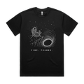 Front mockup of Vestigium XIII luxury 280 GSM heavyweight black t-shirt featuring a dry humour illustration of an astronaut drinking coffee next to a moka pot at a folding camping table on the edge of a massive black hole singularity printed in monochrome ink.